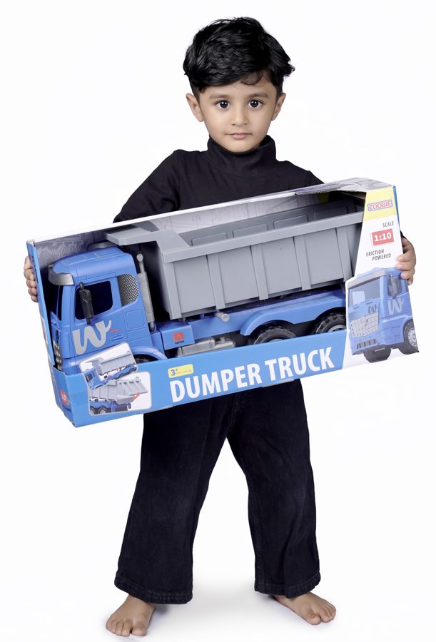 A boy holding the boxed ZOOBIE Dumper Truck