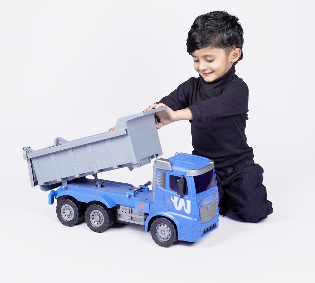 A boy tipping the dumper of a blue ZOOBIE Dumper Truck